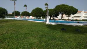 a swimming pool in a park with a grass field at Novo Sancti Petri - Playa, Piscina, Golf y Relax in Chiclana de la Frontera
