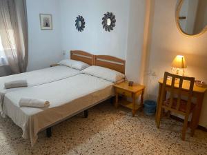 アリカンテにあるGuest House Capitan Mecaのベッドルーム1室(ベッド1台、鏡、椅子付)
