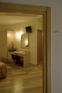 um quarto com uma secretária e uma cozinha com uma mesa em Hotel Granducato em Montelupo Fiorentino