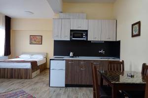 a room with a kitchen and a bed and a table at Борник Хил / Bornik Hill in Devin