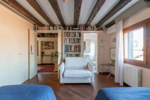 ヴェネツィアにあるPenthouse with Rooftop Terrace and 360 Views of Venice - Venice5thのリビングルーム(白い椅子、本棚付)