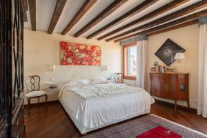 ヴェネツィアにあるPenthouse with Rooftop Terrace and 360 Views of Venice - Venice5thのベッドと壁に絵が飾られた寝室