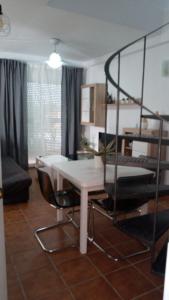 ALCARAVAN 50 في هويلفا: غرفة معيشة مع طاولة وكراسي بيضاء