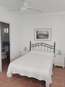 um quarto com uma cama branca com uma moldura preta em ALCARAVAN 50 em Huelva