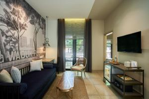 a living room with a blue couch and a tv at Lamandau House in Jakarta