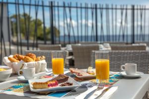 a table with breakfast food and orange juice on a balcony at SOWELL RESIDENCES Chênes Verts in Saint-Raphaël