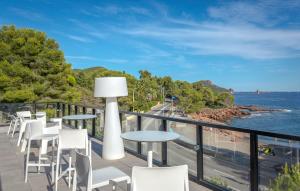 a balcony with tables and chairs and a view of the ocean at SOWELL RESIDENCES Chênes Verts in Saint-Raphaël
