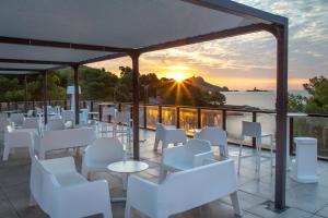a restaurant with white chairs and a view of the ocean at SOWELL RESIDENCES Chênes Verts in Saint-Raphaël