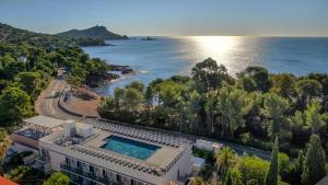 a house with a swimming pool in front of the water at SOWELL RESIDENCES Chênes Verts in Saint-Raphaël