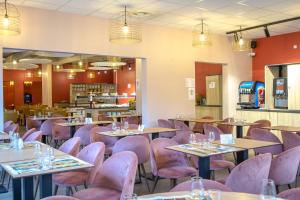 a dining room with tables and pink chairs at SOWELL RESIDENCES Chênes Verts in Saint-Raphaël