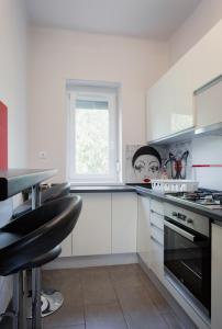 a kitchen with white cabinets and a window at Nimród Apartman in Eger