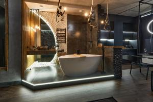 a bathroom with a tub in a room with a sink at KADOR HOME HOTEL downtown in Kyiv