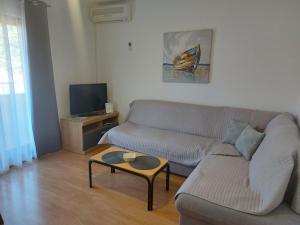 ein Wohnzimmer mit einem Sofa und einem Couchtisch in der Unterkunft Apartments Elizabeta in Draga Bašćanska