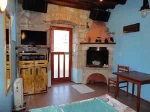 a living room with a stone fireplace and a table and a table sidx sidx sidx at Kod Senke in Komiža