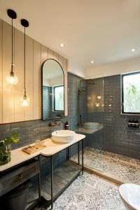 een badkamer met een wastafel en een bad bij Lamandau House in Jakarta