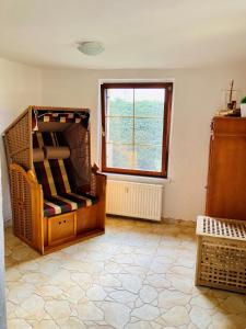 Ferienwohnung Heiligenhagen في Satow: غرفة معيشة مع كرسي ونافذة