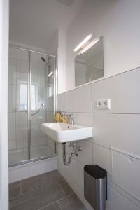 a white bathroom with a sink and a shower at Zentral gelegene, helle Studio Apartments in Nürnberg