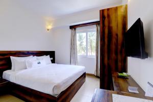 a bedroom with a bed and a tv and a window at MySpace Express GD Inn in Bengaluru