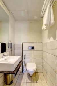 a bathroom with a white sink and a toilet at MySpace Express GD Inn in Bengaluru