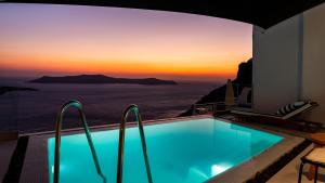 a swimming pool with a view of the ocean at Daydream Luxury Suites in Fira