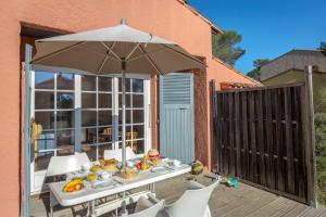 a table with an umbrella on a deck at SOWELL RESIDENCES Chênes Verts in Saint-Raphaël
