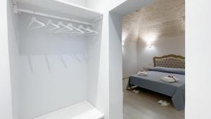 a bedroom with a blue bed and white walls at Palazzo Palasciano in Monopoli