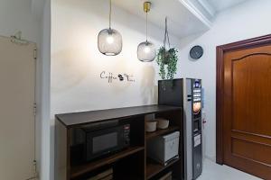 a living room with a microwave and two pendant lights at Hostal La Costa in El Ejido