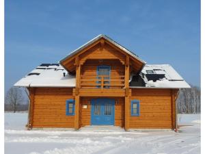 ein Blockhaus mit einer blauen Tür im Schnee in der Unterkunft Traditionshof Lausitzer Teich- und Waldwirtschaft in Petershain