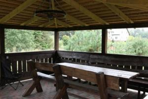 a porch with a wooden table and benches at Liūto kalnas in Trakai