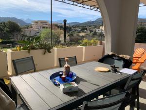 a dining room table with a view of the mountains at Repos à l'ile rousse in LʼÎle-Rousse +3 photos