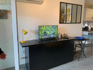 salon z biurkiem i telewizorem w obiekcie Repos à l'ile rousse w mieście LʼÎle-Rousse