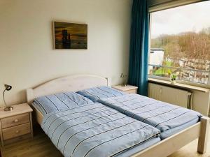 a bed in a bedroom with a window at Ferienwohnung Skowronek am Kurpark in Glücksburg