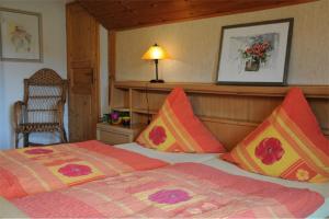 ein Schlafzimmer mit einem Bett, einer Lampe und einem Stuhl in der Unterkunft Ferienwohnungen Bredl in Zwiesel