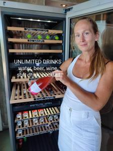 a woman standing in front of an open refrigerator at KEROMOUSSI SEASIDE BOUTIQUE HOTEL - Adult only in Meganisi
