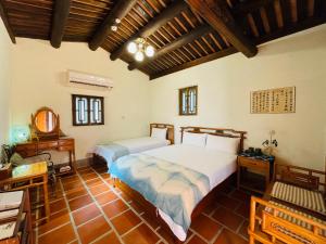 a bedroom with two beds and a table and a desk at Grace Homestay 54 in Jincheng
