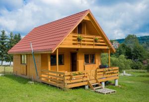 a small wooden cabin with a red roof at Przystanek Bieszczady in Stańkowa