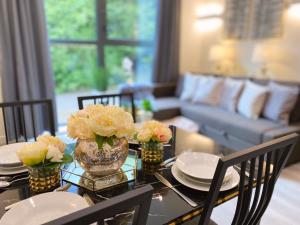 a dining room table with plates and flowers on it at Newpointe Stunning 1-bedroom Serviced Apartment in Milton Keynes