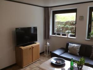 a living room with a couch and a flat screen tv at Ferienwohnung Stork in Möhnesee