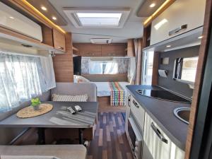 a kitchen and living room in a recreational vehicle at Glamping Caravans In The Crater- גלמפינג קרוואנים במכתש רמון in Mitzpe Ramon