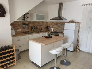 a kitchen with a white refrigerator and a counter with stools at Kuća za odmor "TONI" in Kuna Pelješka