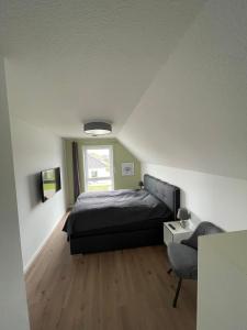 a small bedroom with a bed and a window at Wangerbrise in Wangerland