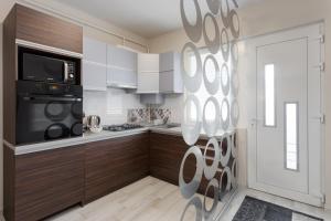 エゲルにあるImpulse apartmanのキッチン(白と茶色のキャビネット、電子レンジ付)