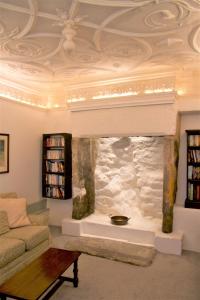 a living room with a stone fireplace with a ceiling at The Merchant's House in Penryn