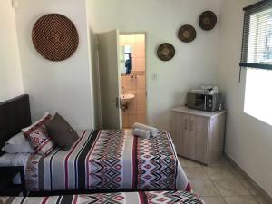a small bedroom with a bed and a microwave at Danamara Garden Studios in Phalaborwa