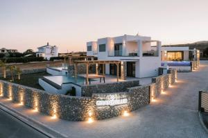 a house with lights on the side of it at Grand Blue Villas Lachania in Lachania