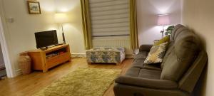 a living room with a couch and a flat screen tv at LAWFIELD R&R in West Kilbride