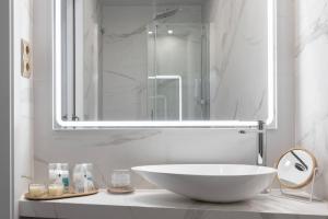 baño con lavabo blanco grande y espejo en La Maison de Barcelone, en Barcelona