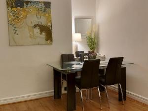 a dining room table with black chairs and a painting at LAWFIELD R&R in West Kilbride