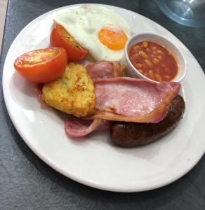 a plate of breakfast food with eggs sausage and beans at Southbank TOWN HOUSE in Torquay