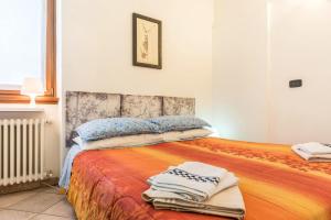 サン・ロレンツォ・イン・バナーレにあるAppartamenti Ciclaminoのベッドルーム1室(大型ベッド1台、タオル付)